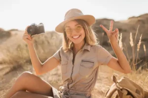 Happy woman on the desert posing with a camera